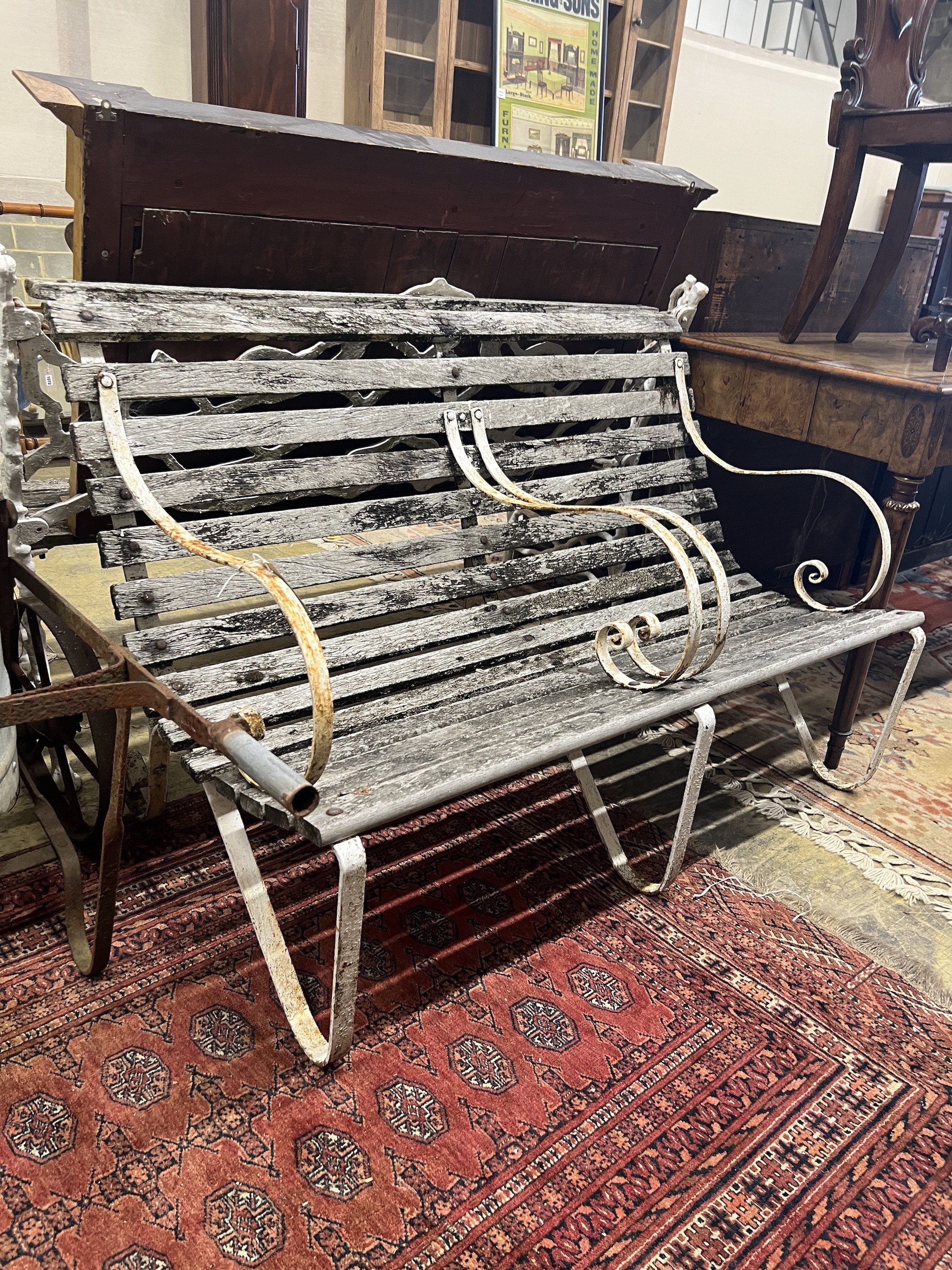 A vintage wrought iron and weathered teak two-seater garden bench, length 121cm, height 82cm